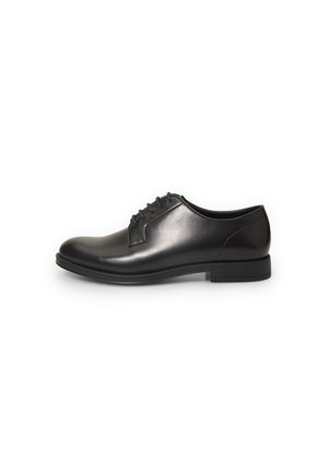 Zapato de vestir de cuero negro con acabado liso, punta redondeada, diseño de cordones de cuatro ojetes y suela de goma de perfil bajo.