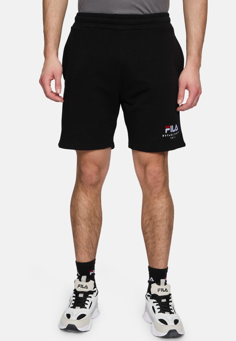 Pantalones cortos de algodón negros con cinturilla elástica, que presentan un logo bordado en rojo y blanco de FILA en la pierna izquierda. Tejido texturizado, diseño hasta la rodilla.