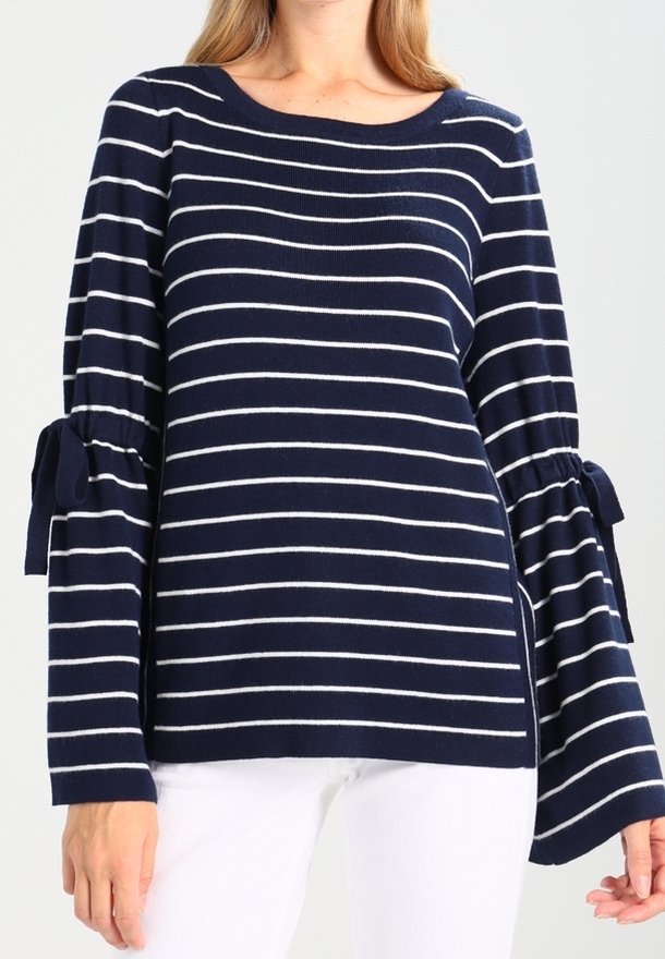 Námořnicky modrý pruhovaný svetr s bílými horizontálními pruhy, se širokými zvonovými rukávy a vázacími detaily na manžetách.