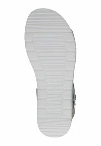 Sole sandálu se texturovaným bílým gumovým povrchem s rýhami a výstupky pro trakci, tvarována s zaoblenou špičkou a plochým podpatkem.