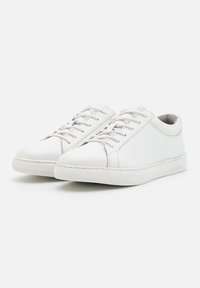 White leather sneakers with a smooth finish, round toe, and six eyelet lace-up closure; rubber sole with textured grip.