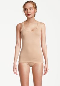 Beige tank top with thin straps and a scoop neckline, paired with matching briefs. Soft, stretchy fabric, minimalist design.