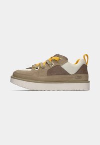 Kreem ja beež sneakers, millel on võrgumaterjal ja nahk, kollased aktsendid, paks valge tald ja peegeldavad hallid paelad. Omab taga tõmbeaasat.