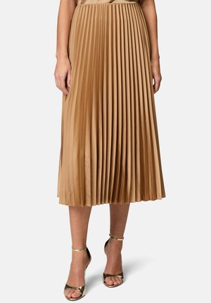 Jupe midi plissée en satin lisse de couleur brun clair. Dotée d'une taille élastique, elle tombe juste en dessous du mollet.