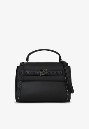 Bolso de hombro de cuero negro que presenta un asa superior, correa desmontable, acentos de tachuelas y una placa de metal con el logo en la parte frontal. Textura suave, forma estructurada.