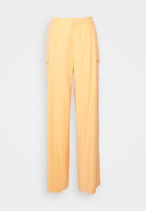 Hochtaillierte, weit geschnittene Hose in Pastellorange mit seitlichen Klappentaschen und Gürtelschlaufen auf einem schlichten, hellen Hintergrund.