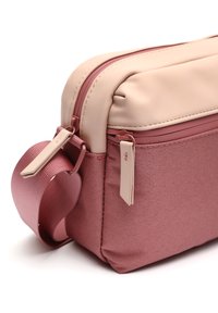 Borsa rettangolare con parte superiore in morbida ecopelle rosa e base in tessuto rosa testurizzato. Presenta una chiusura zip e una maniglia laterale rotonda.