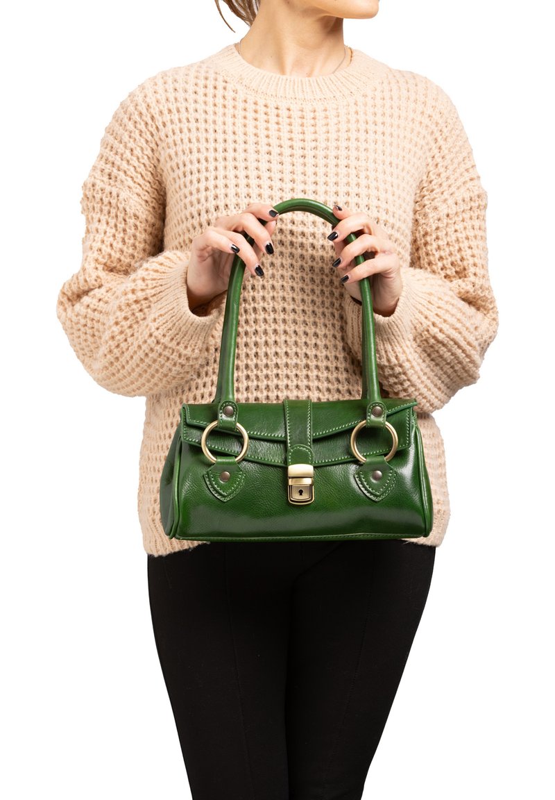 Groene leren handtas met een gladde textuur, dubbele ronde handvatten, een klep aan de voorkant en gouden hardwareaccenten. Draag het met een crèmekleurige trui.