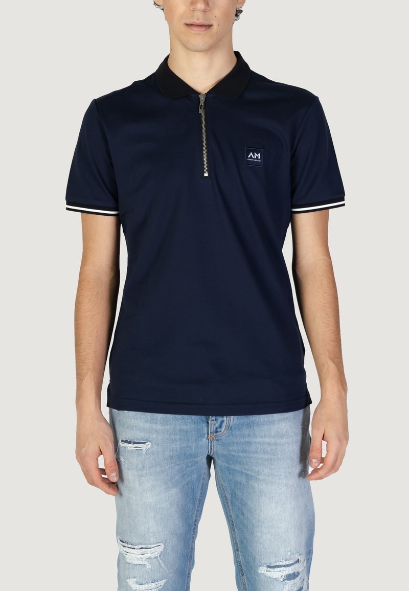 Mornarska polo majica od mekog materijala s ovratnikom na zip, s bijelim prugastim detaljima na rukavima i malim logotipom na prsima.