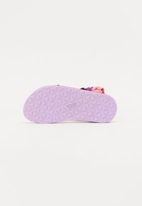 Sola de sapato de borracha roxa com um padrão geométrico texturizado e o nome da marca "Teva" embossado na superfície.