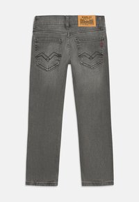 Grå denimjeans med rett snitt, med to baklommer med chevron-søm og en brun etikett på livlinjen.