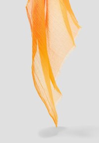 Orangeschal aus leichtem Material, mit einem halbtransparenten Design, fransigen Kanten und einer fließenden Form.