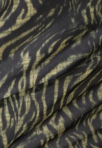 Nahaufnahme von schwarzem Netzstoff mit einem gelb-grünen, abstrakten, zebraähnlichen Muster und sichtbaren Texturfalten.