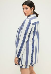 Completo giacca e pantaloncini a righe in blu e bianco. Caratterizzato da motivi geometrici, chiusura con bottoni e una vestibilità rilassata. Tessuto morbido.