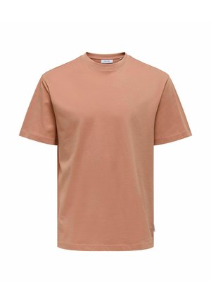 T-shirt a maniche corte, con collo rotondo, in morbido cotone rosa pesco. Presenta una linea dritta e un piccolo etichetta laterale per il branding.