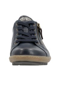 Baskets en cuir marine avec un laçage à l'avant, fermeture éclair sur le côté et semelle en caoutchouc. Présente des coutures minimales et des lacets en tissu texturé.