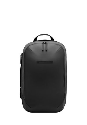 Un sac à dos noir en matériau durable avec une forme rectangulaire élégante, doté de deux zips, d'une poignée supérieure et d'un accent frontal minimaliste.