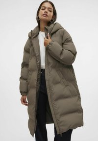 Manteau long rembourré en vert khaki, doté d'une capuche, de poignets élastiques et de poches latérales. Texture lisse avec une fermeture éclair à l'avant.