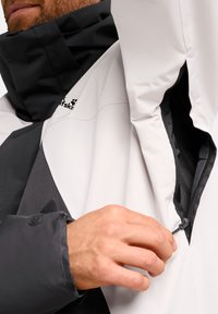 Farbblockierte Jacke mit schwarzem Kragen, grauen und weißen Einsätzen sowie einer Reißverschlusstasche; aus glattem, wasserdichtem Material gefertigt.