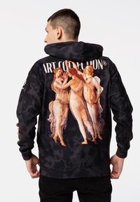 Crna majica s dipped tie-dye uzorkom koja sadrži klasični umjetnički print s tri figure u lepršavim odorama na stražnjoj strani. Tekst iznad: "UMJETNIČKA KOLEKCIJA®."