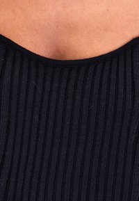 Zwarte ribstof met een scoop halslijn en verticale strepen, met een zachte textuur en een gladde afwerking. Close-up van het halslijngebied.