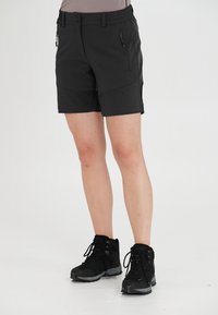 Svarta lätta shorts med elastisk midja, framfickor med dragkedjor och knälång design. Lämpliga för utomhusaktiviteter.