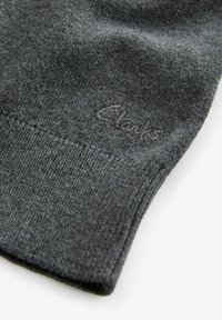 Ciemnoszara, dziana skarpetka o miękkiej fakturze i ściągaczu. Posiada subtelne tonalne logo "Clarks" blisko górnej krawędzi.
