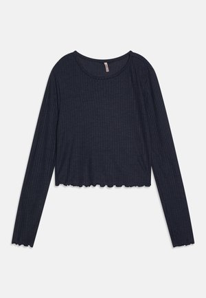 Top cropped de malha canelada em azul marinho escuro, com mangas longas, gola redonda e detalhe em bainha ondulada. Textura suave, design ajustado ao corpo.