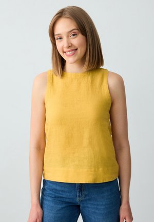 Top senza maniche giallo in lino con scollo rotondo, caratterizzato da una texture liscia e una vestibilità rilassata, abbinato a jeans in denim blu.