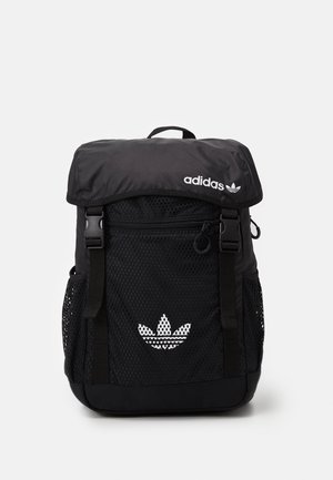 Zaino nero con una parte anteriore in tessuto a rete, spallacci regolabili, pattina superiore e logo Adidas bianco con design a trifoglio sulla parte anteriore.