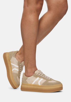 Zapatillas beige con acentos blancos, con parte superior de tela texturizada y detalles de ante. Suela gruesa de goma para mayor altura y estabilidad.