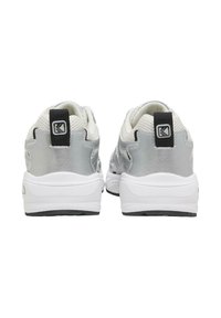 Bijele i srebrne atletske tenisice s glatkom teksturom, podstavljenim ovratnikom i crnim akcentom s logom na poleđini.