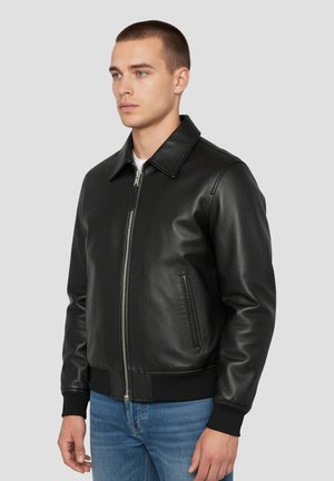 Sort læder bomberjakke med lynlåslukning foran, flad krave, sidelommer og ribstrikkede manchetter. Glat tekstur og tætsiddende design.