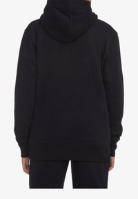 Felpa nera con tasca a marsupio, polsini e orlo a costine. Realizzata in tessuto morbido con una texture liscia. La vista posteriore mostra il cappuccio in posizione.