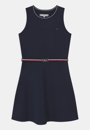 Granatowa sukienka bez rękawów z okrągłym dekoltem, małe logo Tommy Hilfiger na piersi oraz paskiem w paski czerwono-biało-niebieskie w talii.