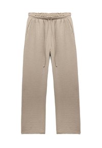 Beige teksturerede wide-leg bukser med elastisk talje og forreste snoretræk, prydet med sidelommer på en hvid baggrund.