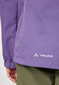 Purple waterproof jacket with a textured finish, featuring green accents and the "Vaude" logo in white at the bottom right.
