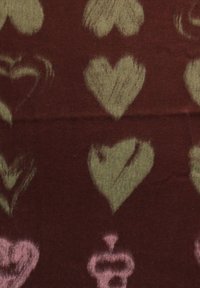 Tissu doux avec un motif de formes de cœur abstraites vert clair et rose sur un fond brun rougeâtre foncé.