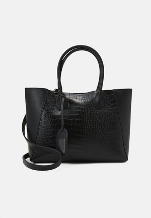 Black handbag with a textured crocodile design on one side, smooth material on the other, two handles, and a removable strap.