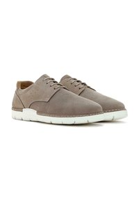 Braune perforierte Lederschuhe mit weißen Gummisohlen, die ein niedriges Profil haben, eine Schnürung aufweisen und dezente Nähte besitzen.