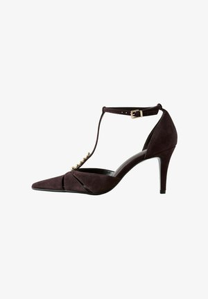 Décolleté in suede marrone scuro con punta a punta, tacco alto, cinturino a T, fibbia alla caviglia e perline decorative dorate lungo il cinturino frontale.