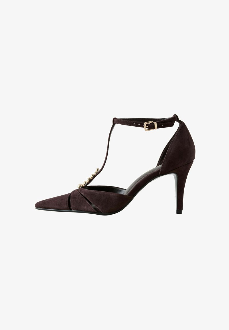 Escarpin à bout pointu en daim marron foncé avec bride en T, boucle à la cheville et perles dorées décoratives le long de la bride avant.