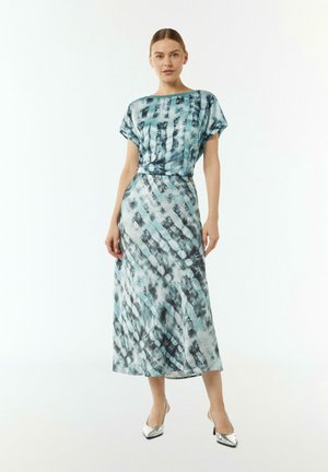 Sukienka w odcieniach niebieskiego i szarego w stylu tie-dye z krótkimi rękawami, luźnym krojem i długą, zwiewną spódnicą. Charakteryzuje się gładką fakturą tkaniny i subtelnym wzorem.