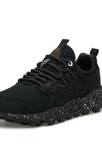 Sneaker nera con tomaia testurizzata, caratterizzata da un design elegante, punta arrotondata e suola maculata nera e bianca con battistrada spesso e lacci resistenti.