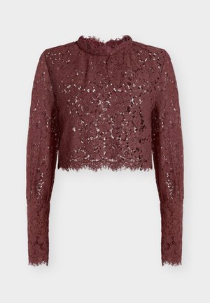 Crop top en dentelle bordeaux avec manches longues et col montant. Présente des motifs floraux, un ourlet festonné et une texture transparente.