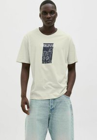 Lichtgroen T-shirt met een rechthoekige grafische afbeelding van palmbomen en de tekst "ORIGINALS". Casual pasvorm, korte mouwen, gemaakt van katoen.