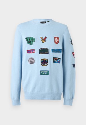 Világoskék kereknyakú pulóver több hímzett folttal, melyek logókat, szöveget és madármotívumot ábrázolnak elöl és az ujjon.