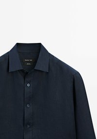 Navy button-up shirt with a classic collar, crafted from 100% linen. Features a textured surface and four front buttons. Massimo Dutti label visible.