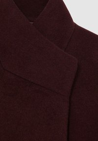 Bordo vuneni kaput s teksturiranom završnom obradom, sa modernim dizajnom preklopnog ovratnika i čestim linijama za elegantnu siluetu.
