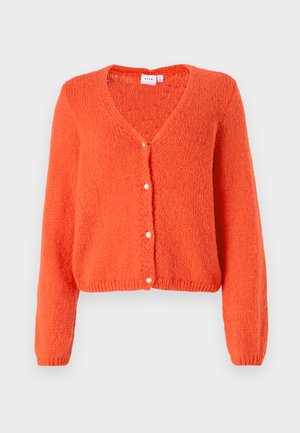 Gebreide oranje cardigan met een V-hals, lange mouwen en vijf knopen aan de voorkant. Textuurstof en een cropped zoom voegen detail toe.